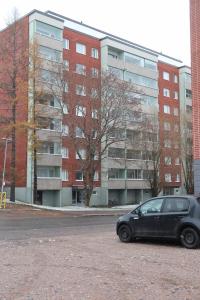 ein schwarzes Auto, das vor einem Gebäude parkt in der Unterkunft Havi Apartment in Riihimäki