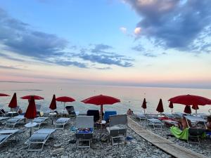 a group of chairs and umbrellas on a beach at Calabria Experience **** in Montegiordano +14 photos