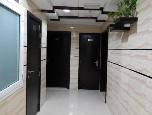 a hallway with two black doors in a building at Flexible Small Partition Room Near MOE in Dubai