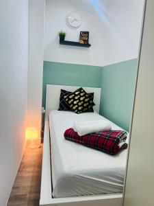 a small bed in a room with a mirror at Flexible Small Partition Room Near MOE in Dubai