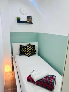 a small bedroom with a white bed with pillows at Flexible Small Partition Room Near MOE in Dubai