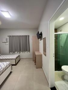 ein Bad mit einem WC, einer Dusche und einem Waschbecken in der Unterkunft Hotel Neon - próximo a 25 de março, Bom Retiro e Brás, á 2min do mirante Sampa SKY e pista de skate Anhangabaú in São Paulo