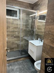 Un baño con ducha, inodoro y lavabo. en NEXT LEVEL APART HOTEL, en Oradea