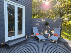 two chairs and a table on a deck at le cocon d'amour " tiny-house avec jaccuzi privé " in La Chapelle-du-Fest