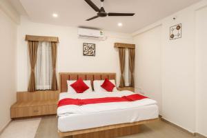 a bedroom with a large bed with red pillows at SpringPetals Serviced Apartments in Bangalore