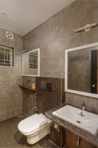 a bathroom with a toilet and a sink at SpringPetals Serviced Apartments in Bangalore