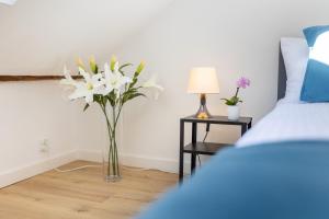 a vase of white flowers in a bedroom with a bed at Apartment with Entresol Old Town Krakow in Krakow