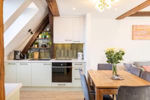 a kitchen and dining room with white cabinets and a wooden table at Apartment with Entresol Old Town Krakow in Krakow