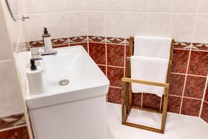 a bathroom with a white sink and a chair at Apartment with Entresol Old Town Krakow in Krakow