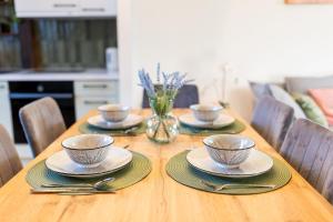 a wooden table with four bowls and plates on it at Apartment with Entresol Old Town Krakow in Krakow