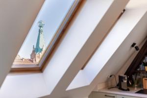 a view of the spire of a building through a window at Apartment with Entresol Old Town Krakow in Krakow