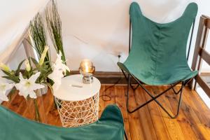 a room with two green chairs and a table and flowers at Apartment with Entresol Old Town Krakow in Krakow