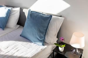 a bed with blue and white pillows and a lamp at Apartment with Entresol Old Town Krakow in Krakow