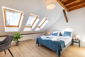 a attic bedroom with a bed and windows at Apartment with Entresol Old Town Krakow in Krakow