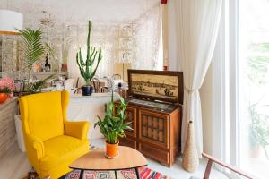 a living room with a tv and a yellow chair at Hotel Corallo Garnì in Cattolica