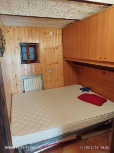 - une chambre avec un lit dans un mur en bois dans l'établissement Locazione Turistica delle Dee, à Pescocostanzo