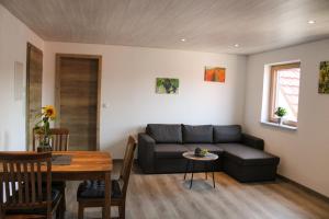 sala de estar con sofá y mesa en Ferienwohnung Pfrang, en Michelau