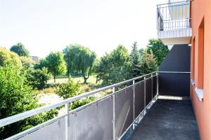 a balcony of a building with a view of a park at Sami Swoi Noclegi 4 in Bełchatów