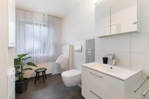 een witte badkamer met een toilet en een wastafel bij Ferienwohnungen Lilie Und Dahlie in Münsingen