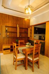 uma sala de jantar com uma mesa de madeira e cadeiras em Mgahinga residence 
