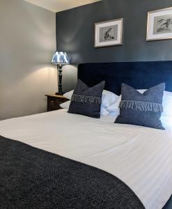 a bedroom with a large bed with blue walls at The Keepers Arms in Quenington