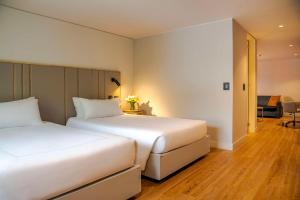 波哥大的住宿－NH波哥大帕維永羅伊爾酒店，走廊的客房内设有两张白色的床