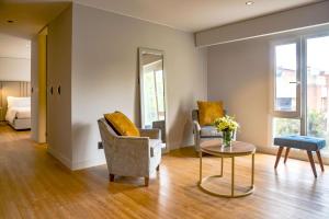 波哥大的住宿－NH波哥大帕維永羅伊爾酒店，客厅配有两把椅子和一张桌子