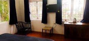 - une chambre avec un lit, une chaise et des fenêtres dans l'établissement HappyHuts at Green valley view, à Kodaikānāl