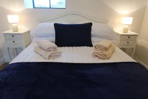 a bedroom with a bed with towels on it at Tara’s Hill Cottage in Kilcoo