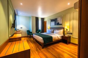 Clarks Inn Express, Rishikesh في ريشيكيش: غرفة في الفندق مع سرير ومكتب