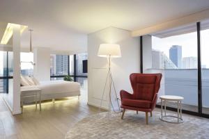 a bedroom with a bed and a red chair at NH Collection Mexico City Reforma in Mexico City