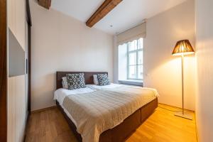 een slaapkamer met een bed met een lamp en een raam bij Yoga Residence Apartments in Tallinn