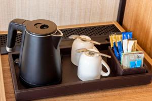 a tray with a tea kettle and two white birds at NH Amsterdam Leidseplein in Amsterdam