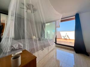 a bedroom with a bed with a mosquito net at Dos terrazas vistas a la montaña in Vinaròs