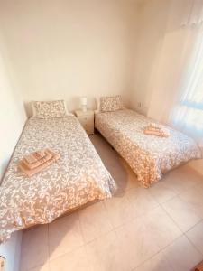 Un dormitorio con dos camas y una ventana. en Marina Apartments - Playas, en Santa Pola