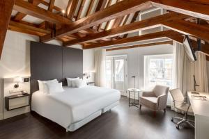 1 dormitorio con 1 cama blanca grande y 1 silla en NH Collection Amsterdam Barbizon Palace, en Ámsterdam