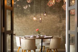 a dining room with a table with chairs and lights at NH Collection Amsterdam Barbizon Palace in Amsterdam