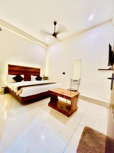 - une chambre avec un grand lit et une table dans l'établissement HOTEL SR GRAND, à Gorakhpur