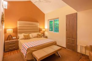 Un dormitorio con una cama grande y una ventana en StayVista at Oberoi's Chalet en Bhīm Tāl