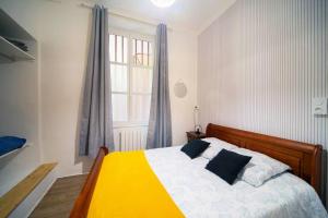 sypialnia z żółtym i białym łóżkiem z oknem w obiekcie Cabana & Le Sirène - Proche Centre-Ville w mieście Mâcon