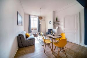 salon ze stołem i żółtymi krzesłami w obiekcie Cabana & Le Sirène - Proche Centre-Ville w mieście Mâcon