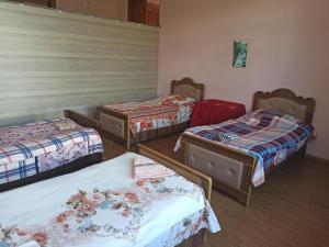 a group of three beds in a room at Cozy home in Zugdidi