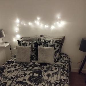 um quarto com uma cama com um edredão preto e branco em Home sweet to Paris em Clichy
