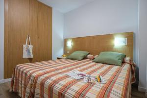 a bedroom with a large bed with a blanket at Apartamentos California in Salou