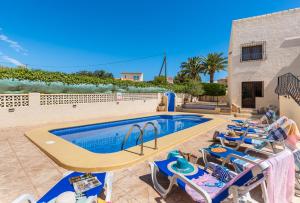 een zwembad met ligstoelen en een resort bij Villa Agudin - PlusHolidays in Calpe