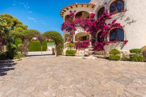 een huis met bloemen erop bij Villa Agudin - PlusHolidays in Calpe