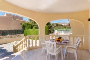 een eetkamer met een tafel en stoelen op een balkon bij Villa Agudin - PlusHolidays in Calpe