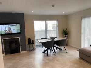 a living room with a table and chairs and a tv at 15 Waterwheel Wharf, Annalong in Newry