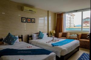 a hotel room with two beds and a window at DMZ Hotel ,Central Hue ,Near Perfume River in Hue +197 photos