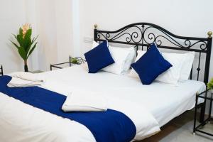 een slaapkamer met 2 bedden met blauwe en witte kussens bij Rising Shemesh Home Stay in Udaipur